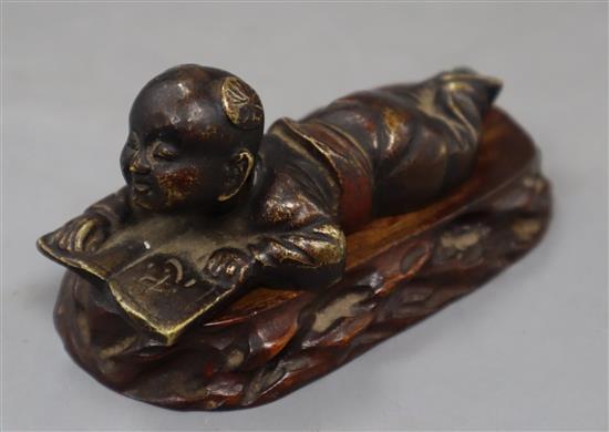 A Chinese bronze of a boy reading, height 9cm